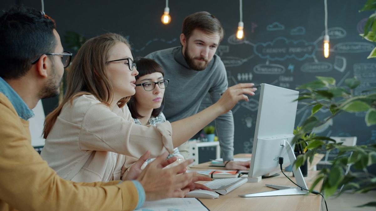 Csapat egy monitor előtt megbeszéli az adatokat